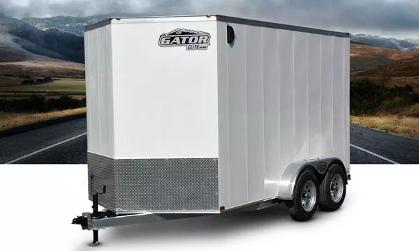 Gator Elite Enclosed Trailer 7’ x 14’ with galvanized frame and tandem axles, shown in light grey finish on a rural road backdrop.