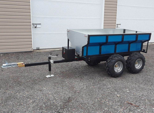 ATV Hydraulic Dump Trailer with a blue cargo area parked on a concrete surface.