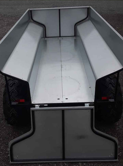 ATV Hydraulic Dump Trailer on a dark surface with a blurred natural background