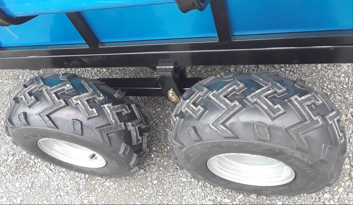 Close-up of two large black tires with tread pattern on ATV Hydraulic Dump Trailer