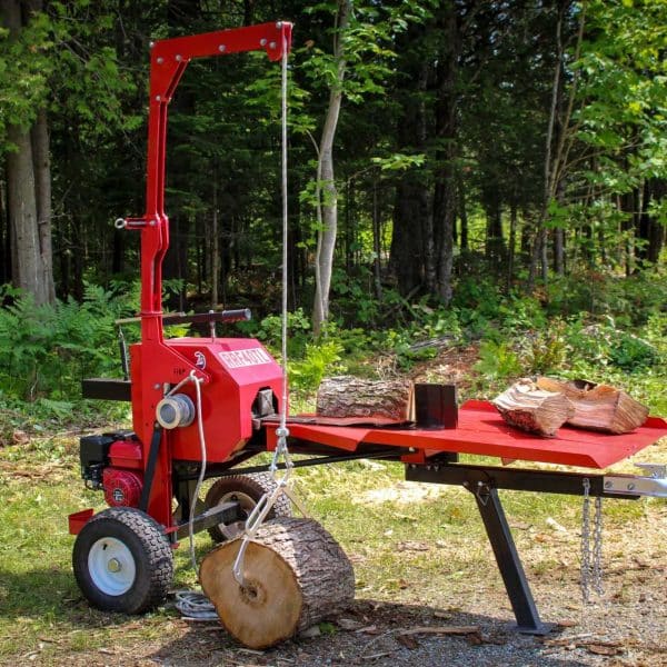 Red RRF40TL – 40 Tons Kinetic Log Splitter in a forest setting with logs and a table.