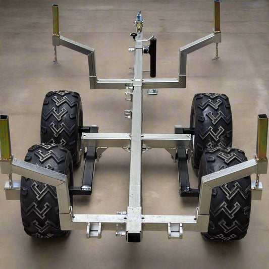 Heavy-duty ATV/UTV walking beam logging trailer with a galvanized frame, tandem wheels, and removable bunks for efficient log hauling.