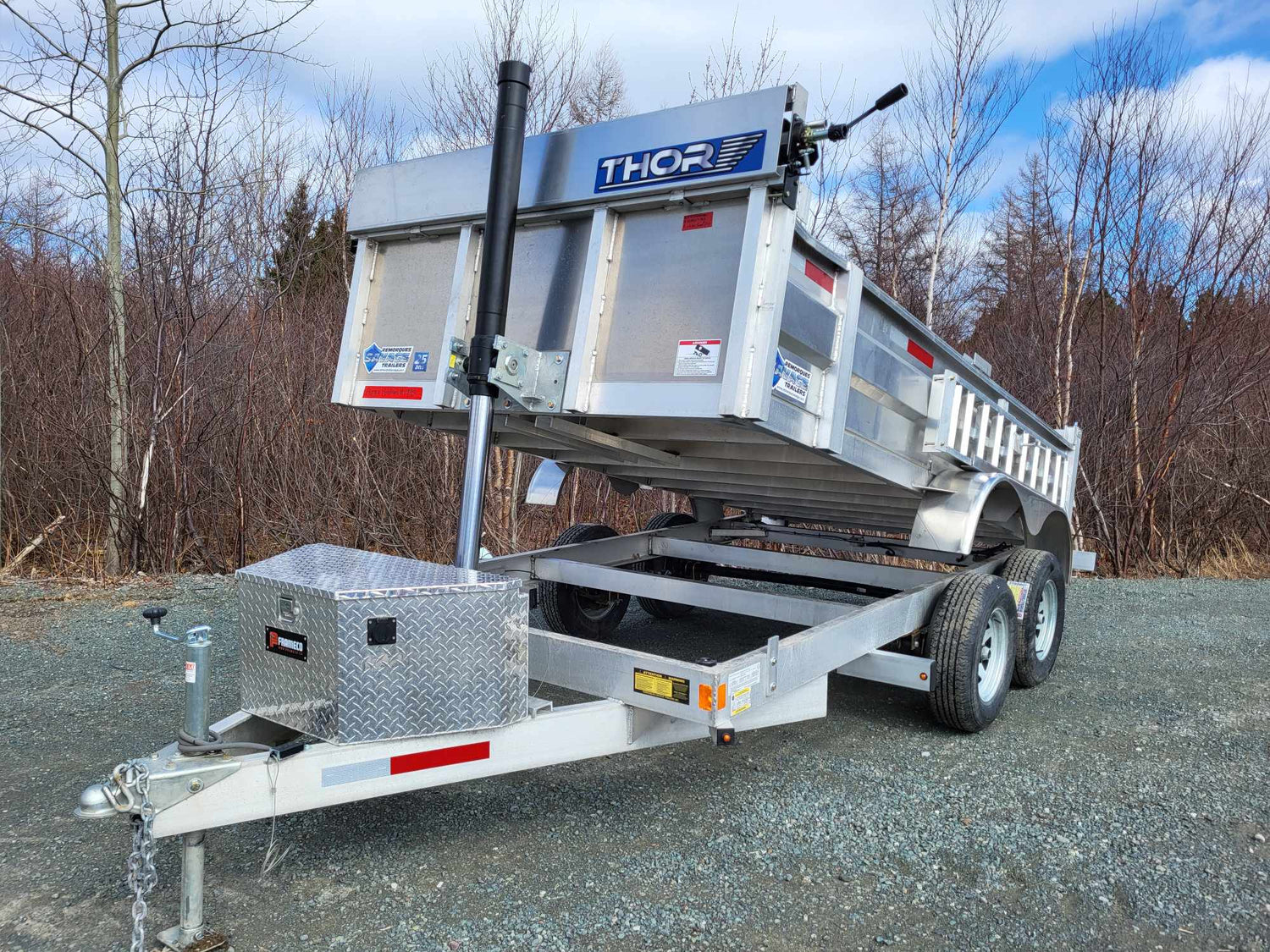 Aluminum dump trailer with lifted bed, front and side view showing hydraulic cylinder and toolbox.