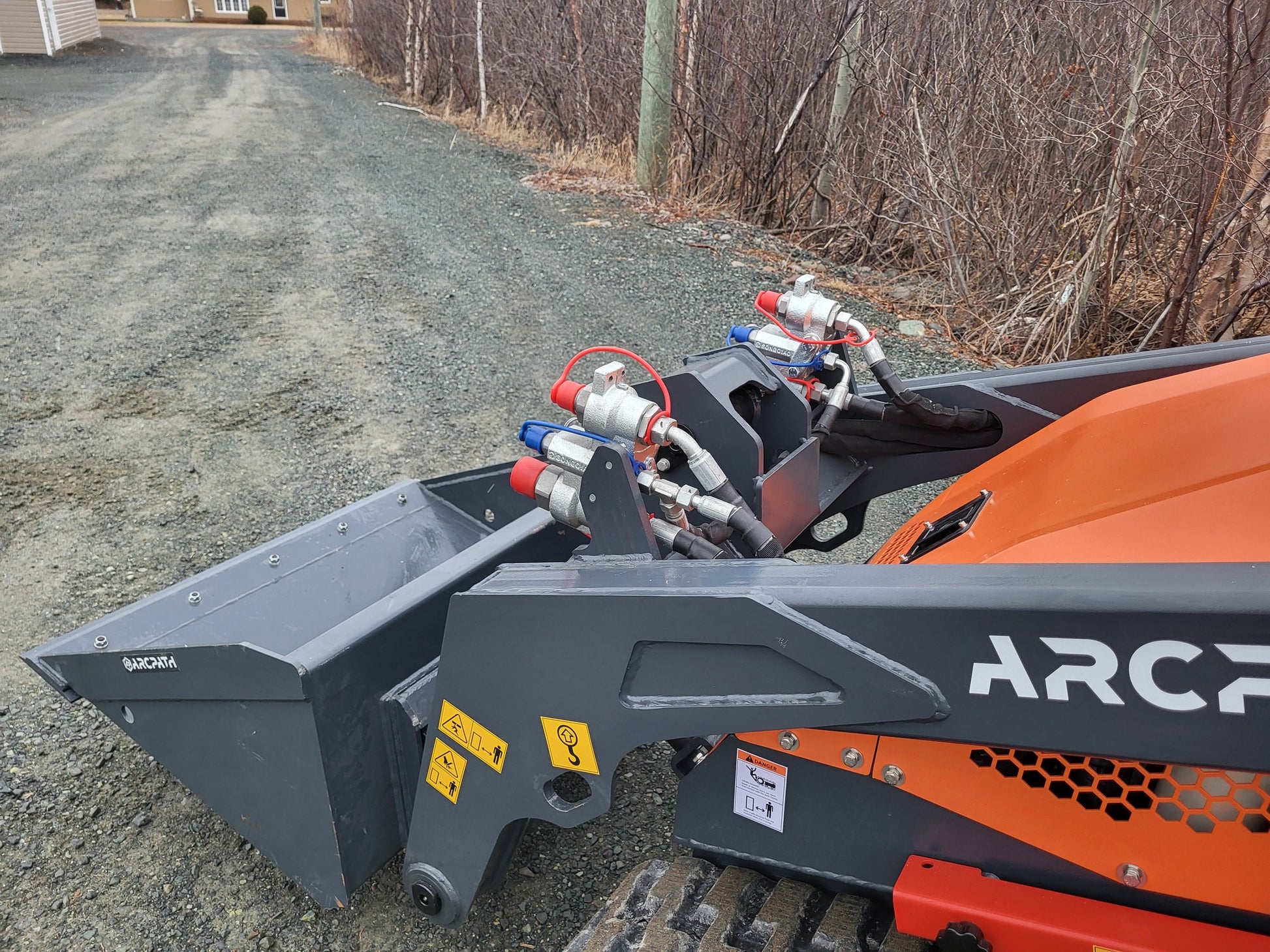 Hydraulic connections and bucket closeup of ATL 1000 Mini Track Loader by ArcPath.