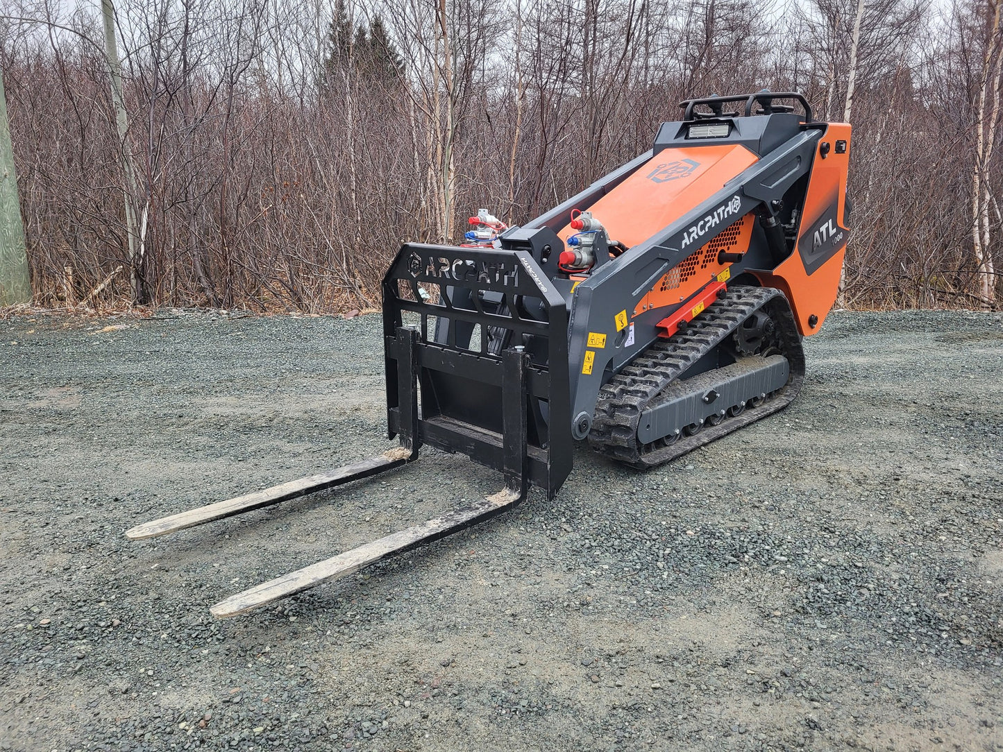 ATL 1000 Mini Track Loader with forks attachment ready for lifting.