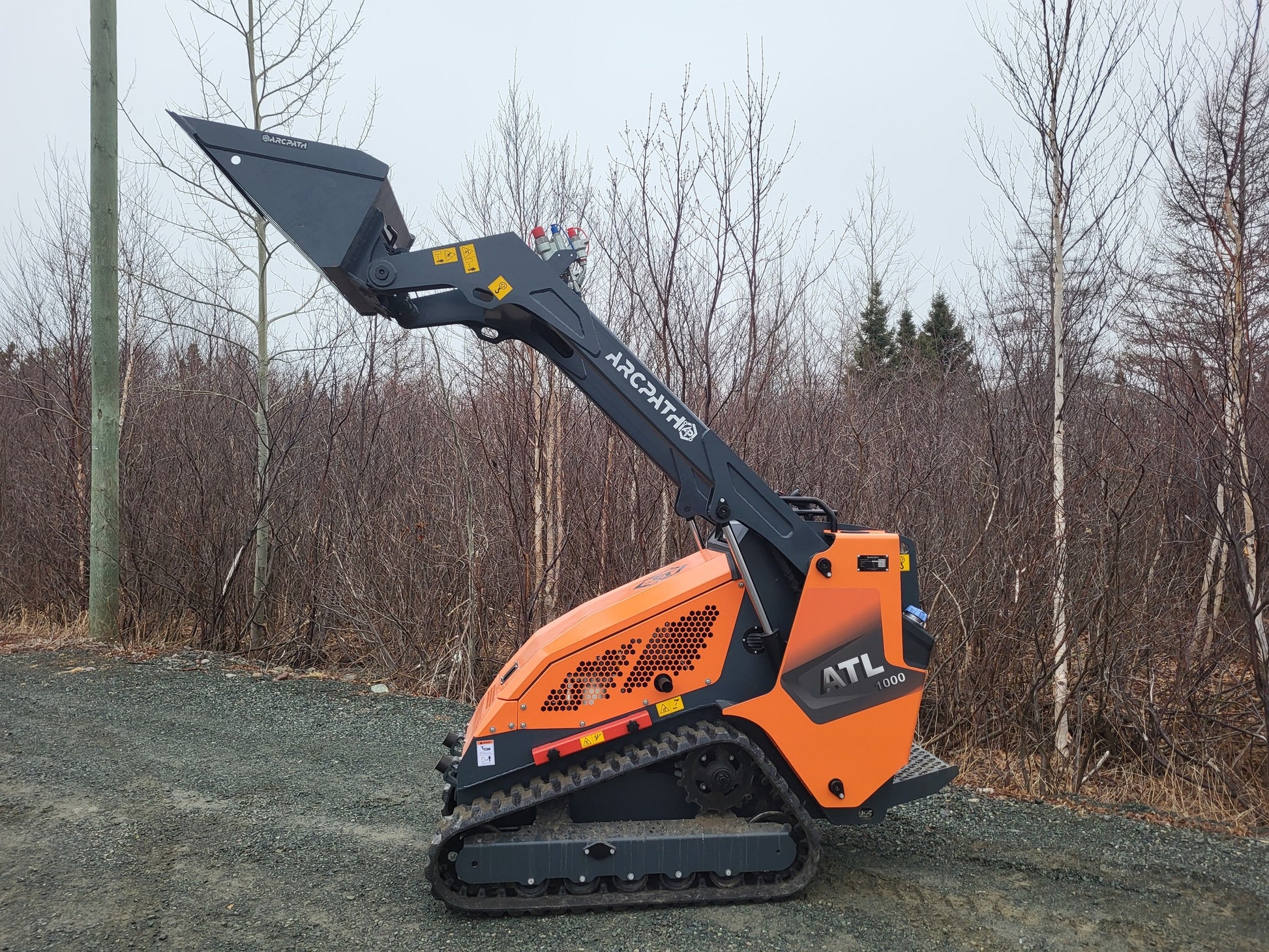 Side view of ATL 1000 Mini Track Loader with raised bucket.